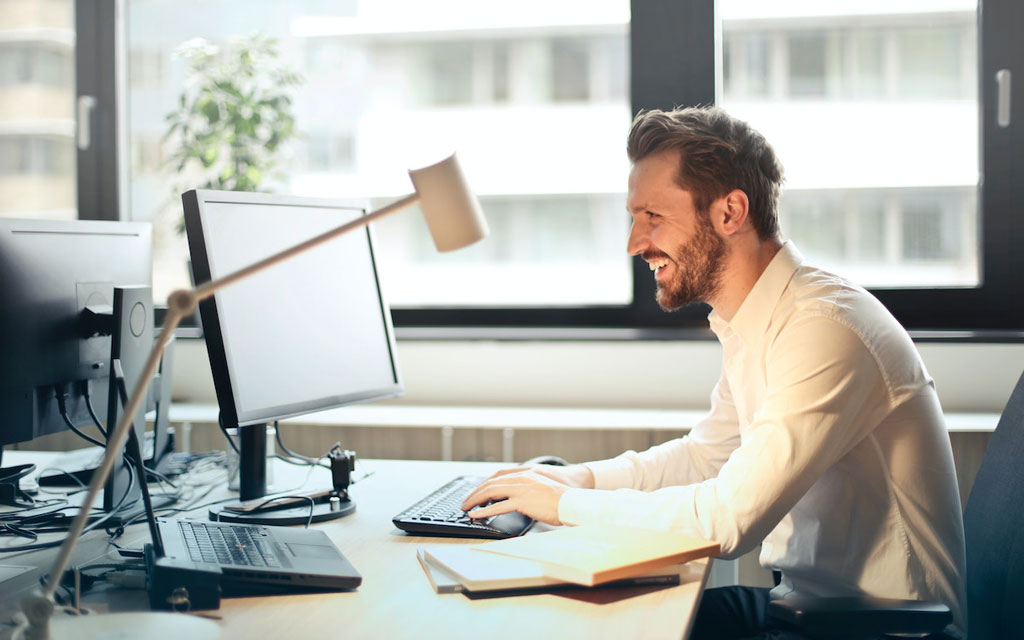 Man happily gazing at his computer screen
