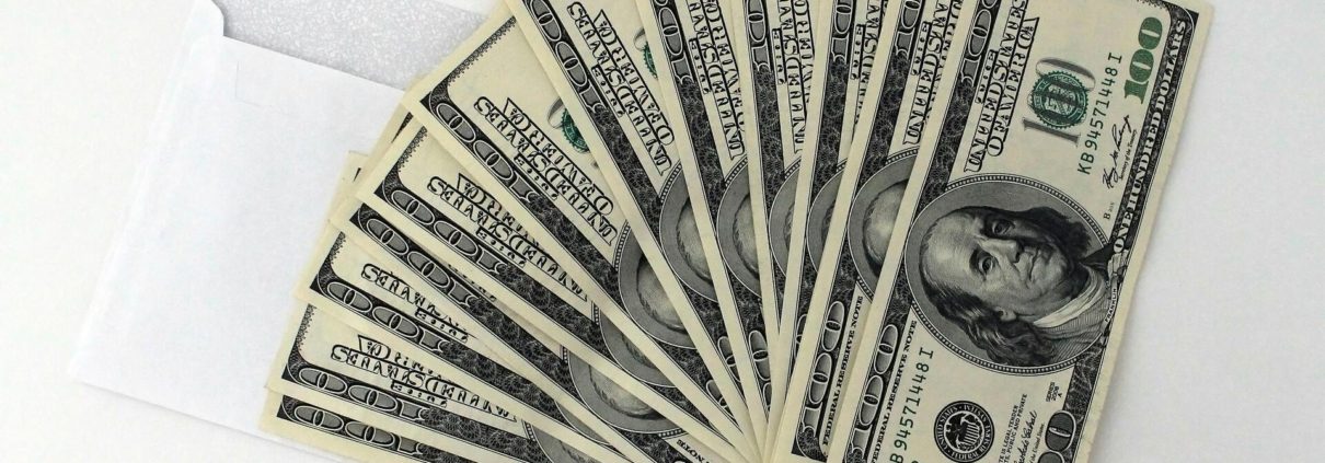 An envelope filled with $100 bills, symbolizing what a personal loan is